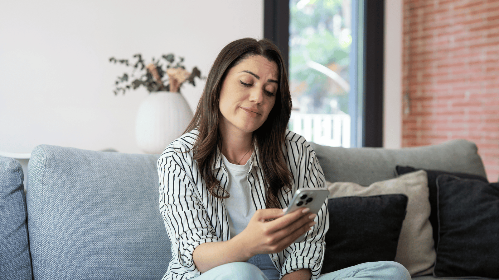 Woman looking skeptically at her phone while scrolling social media