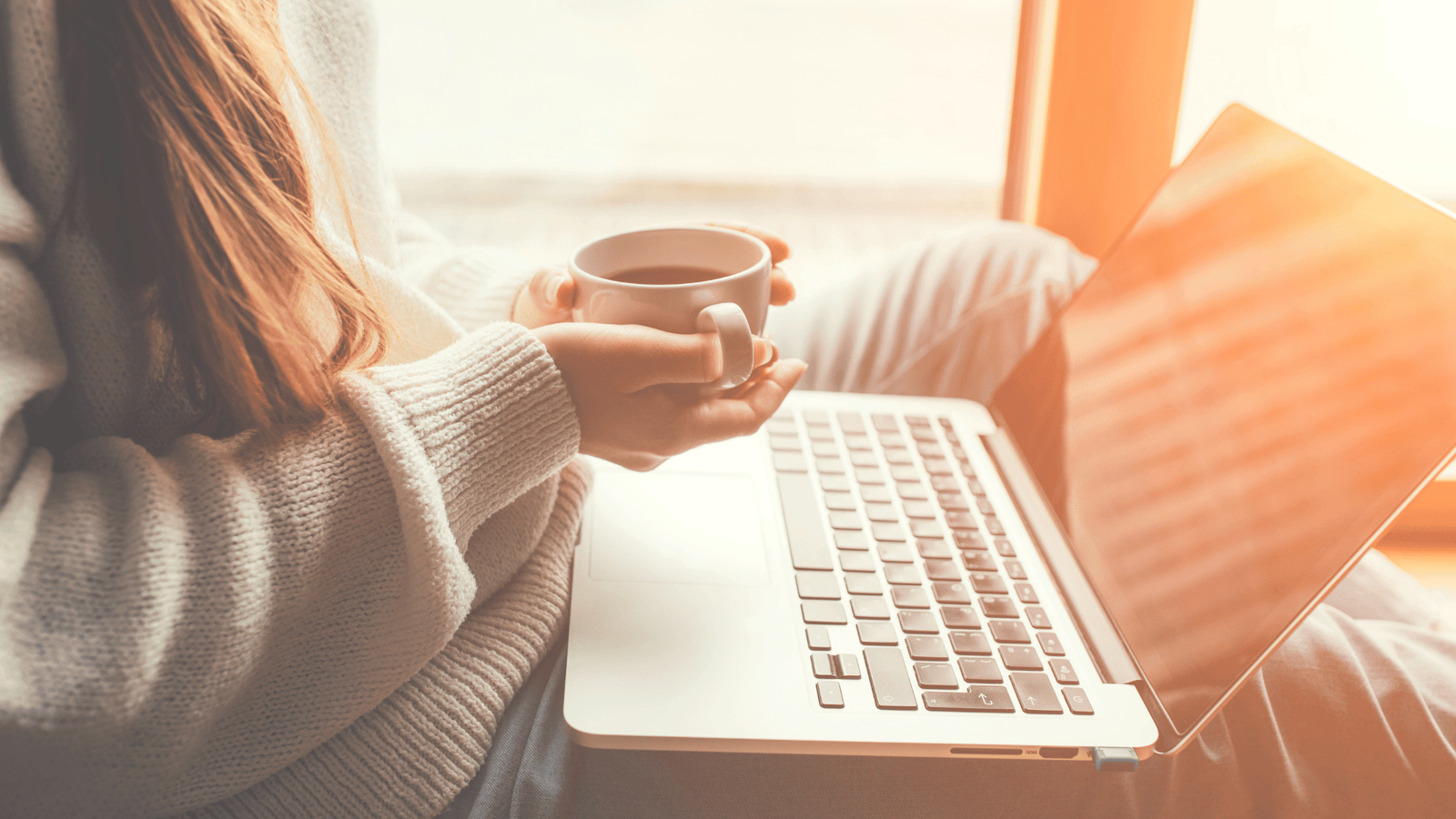A working mom sits with a laptop, building her work optional lifestyle one focused Friday at a time.